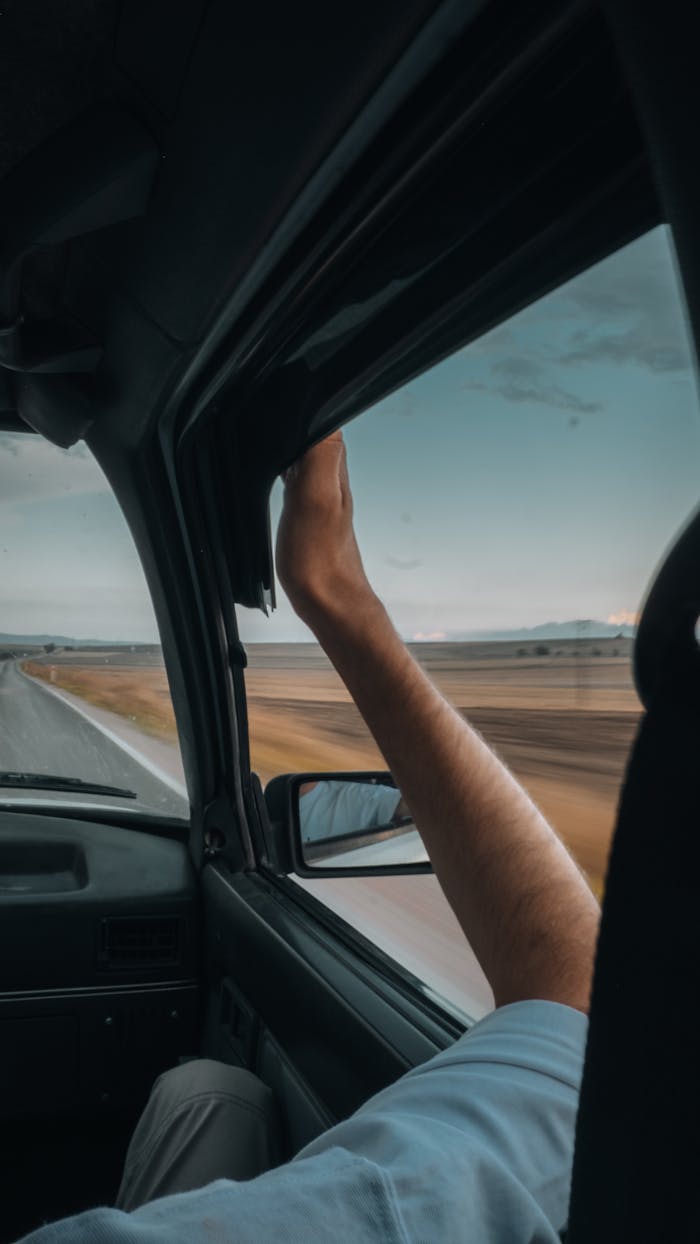 Arm out the car window enjoying a scenic drive through Merzifon, capturing freedom on the open road.